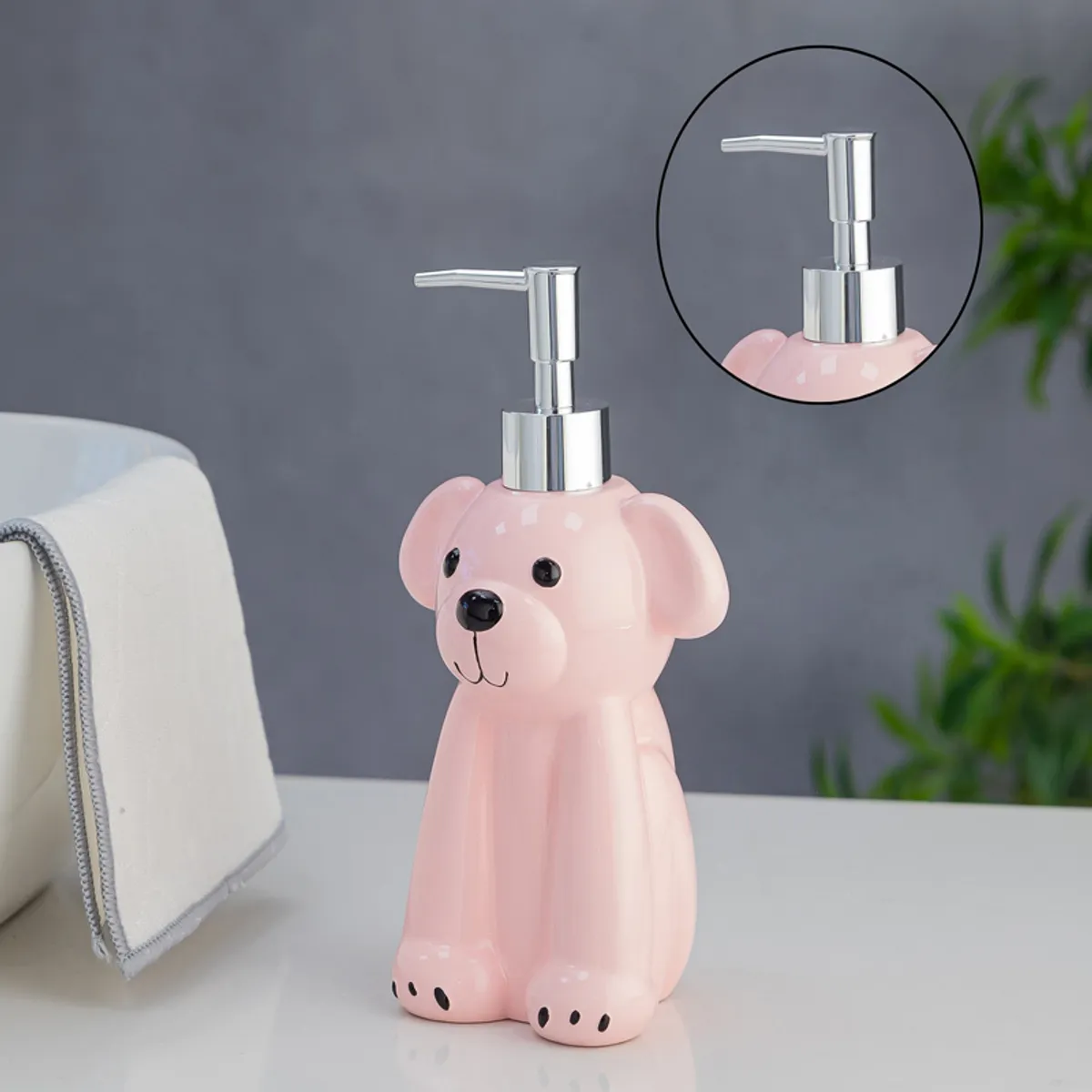 Pink dog-shaped liquid dispenser with close-up of silver pump