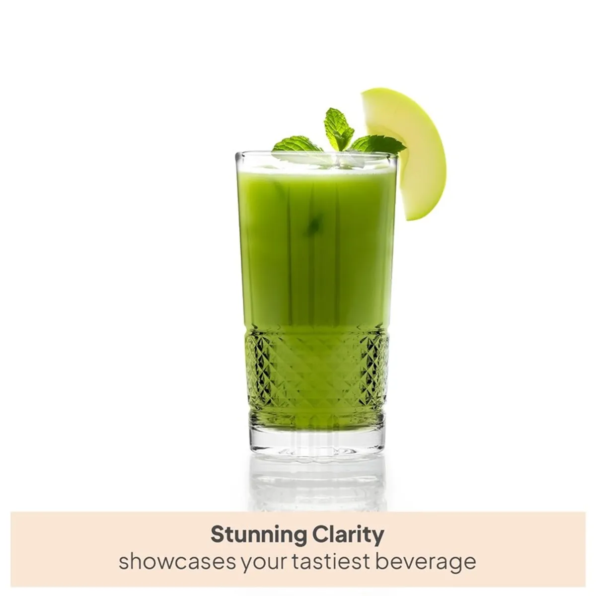 A transparent textured drinking glass filled with green juice and garnished with mint.