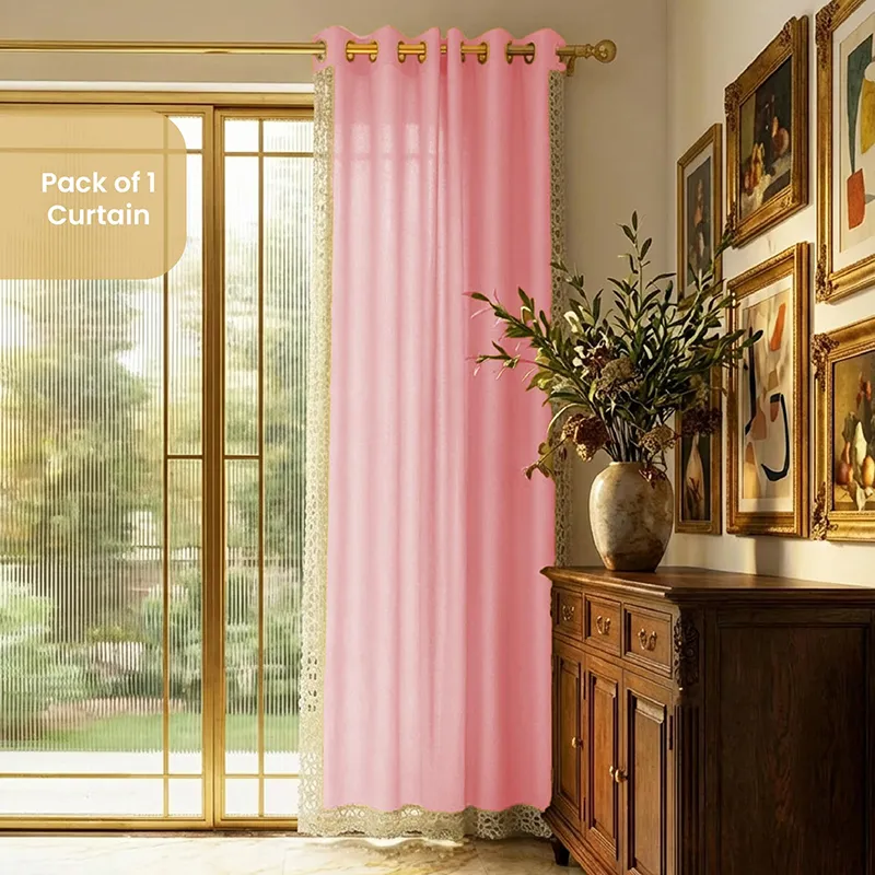 Pink eyelet curtain with lace edging hung by a glass door