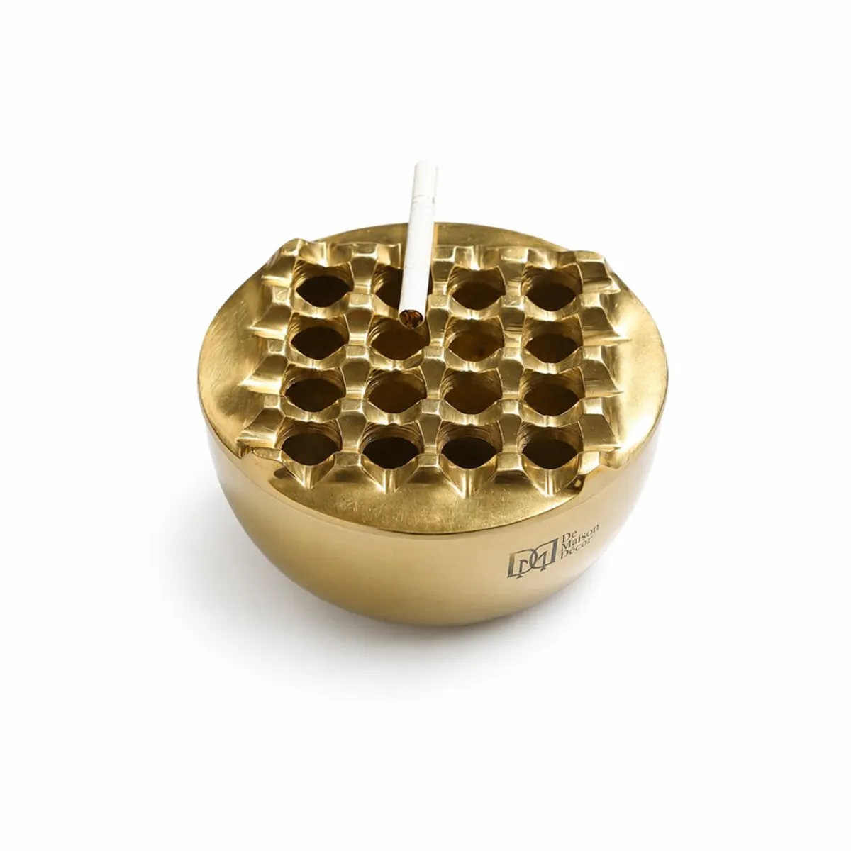 Close-up of the gold ash tray with a cigarette in the centre opening