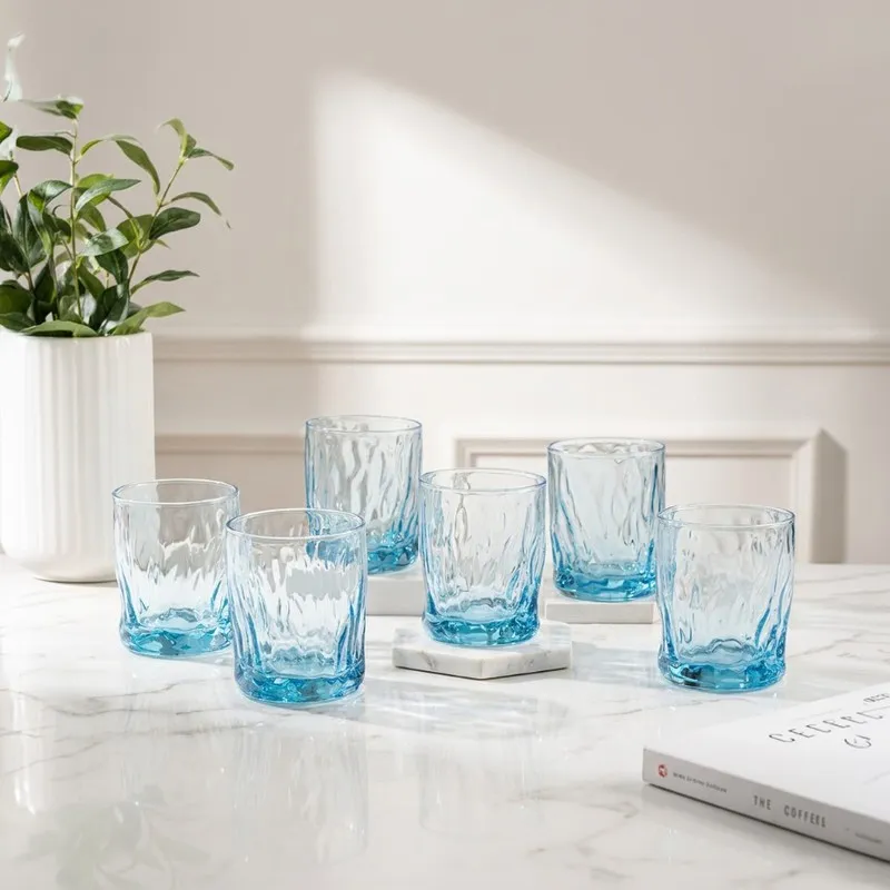 Six ocean blue textured whiskey glasses arranged on a tabletop