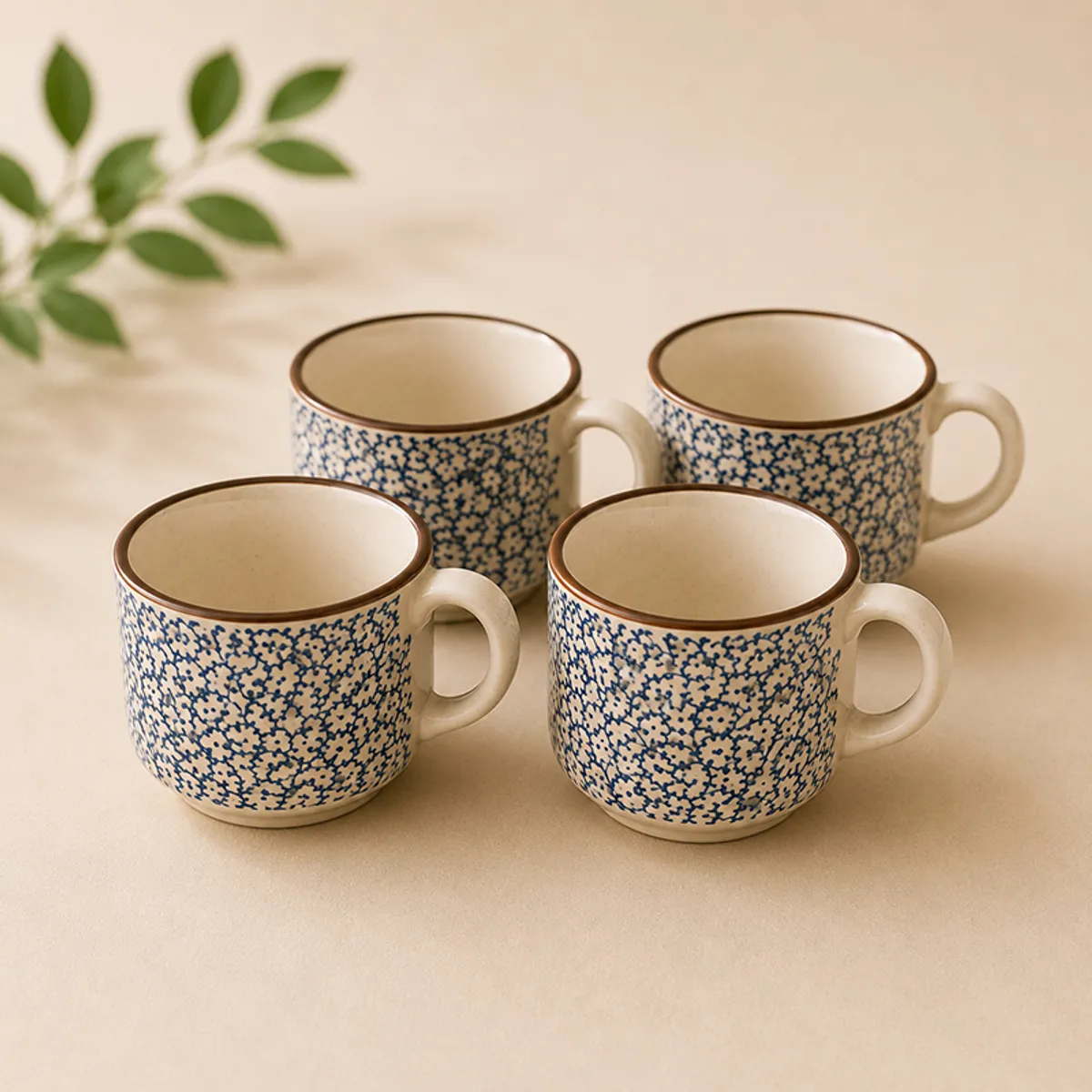 Four blue-and-white patterned ceramic tea cups arranged together