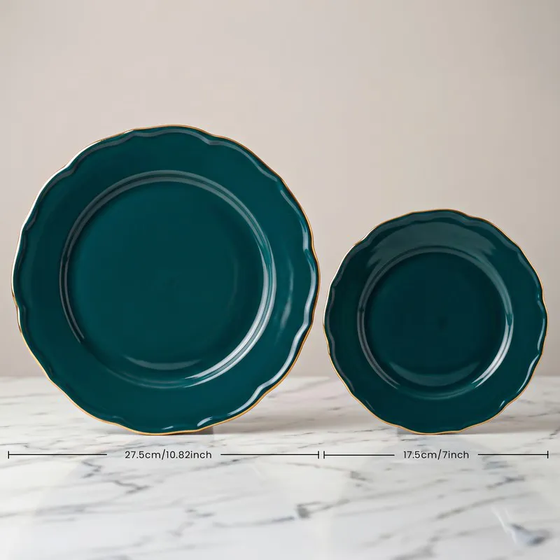 Dark teal large and small plates with scalloped edges and gold rims
