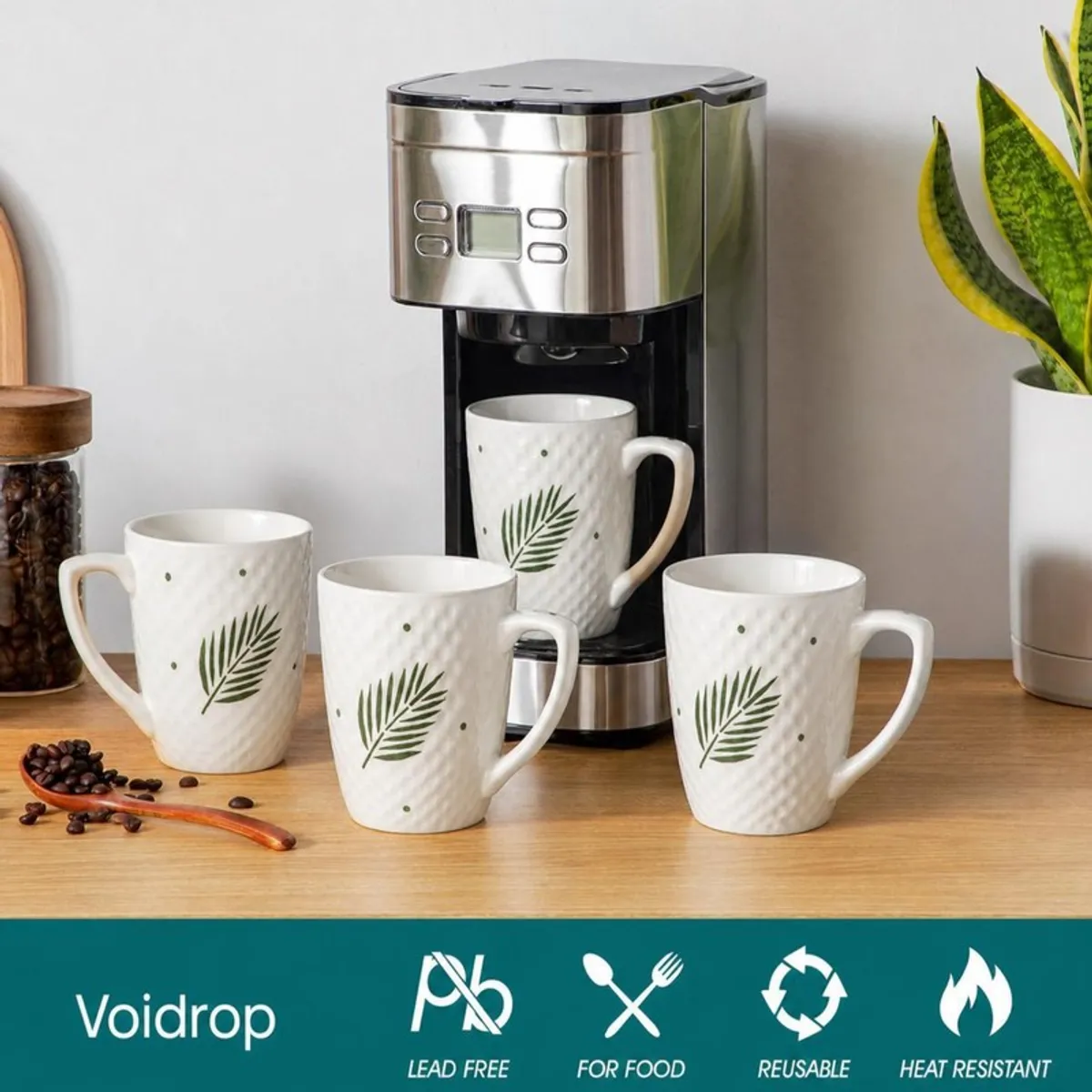 White leaf-print mug placed beneath a coffee machine with three mugs nearby