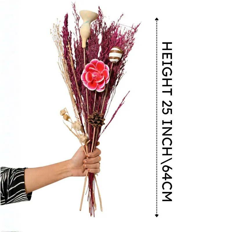 Hand holding a tall pink dried flower bouquet against a white background