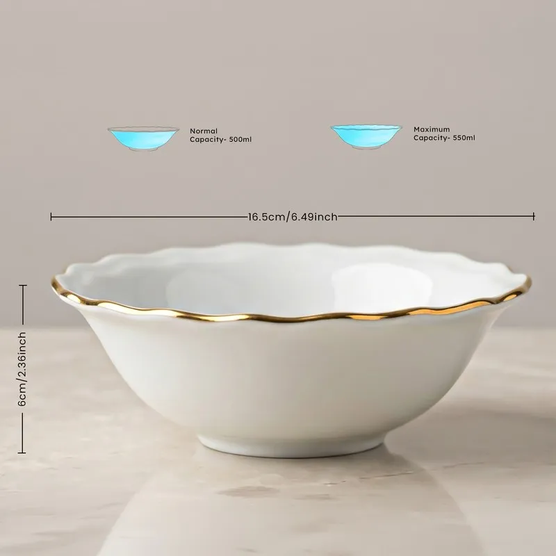 White serving bowl with gold rim and scalloped edge on a neutral background