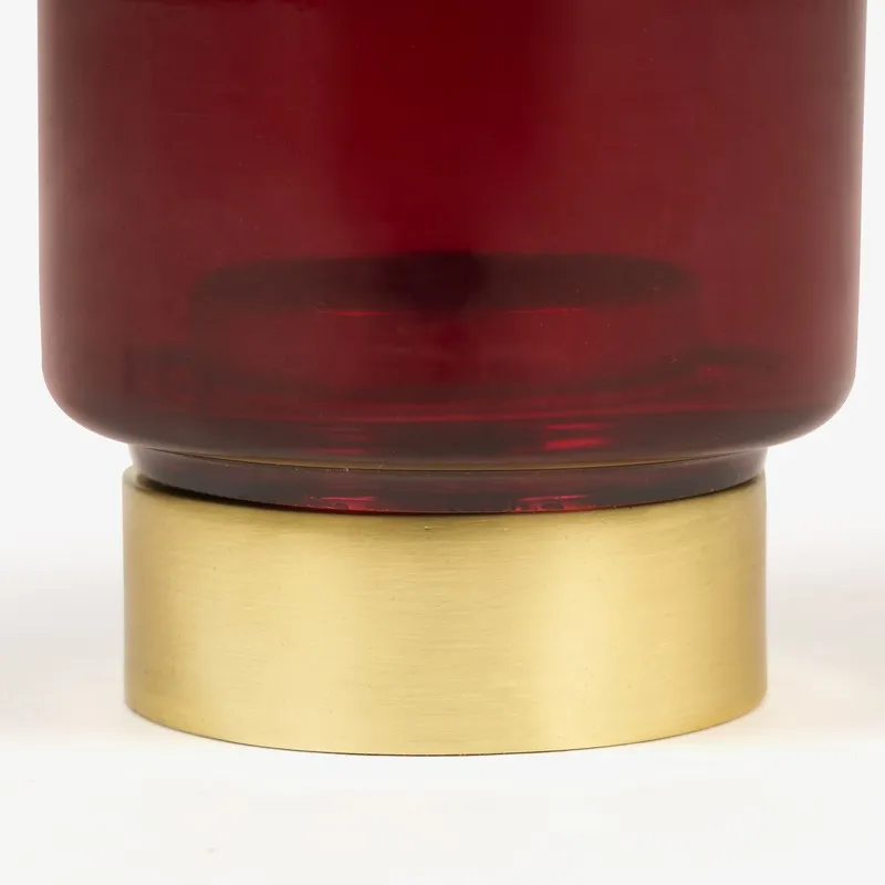 Close-up of ruby glass candle holder base in gold finish