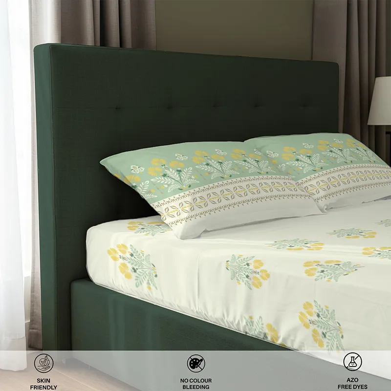Side view of off-white and green floral bedsheet on a dark green bed