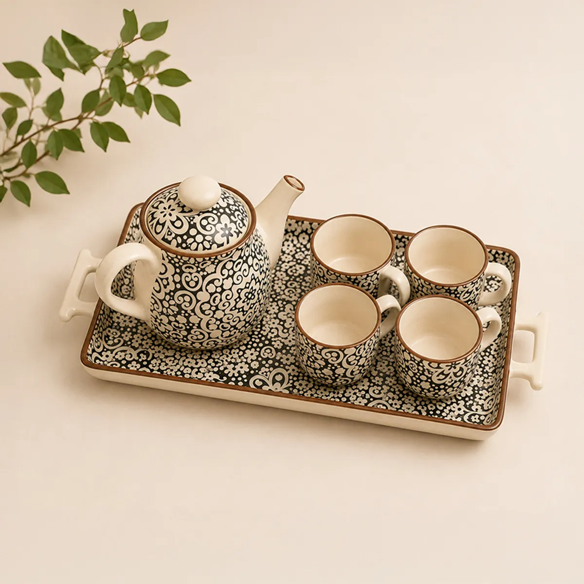 Angled view of an ornate black-and-white ceramic tea set on a tray