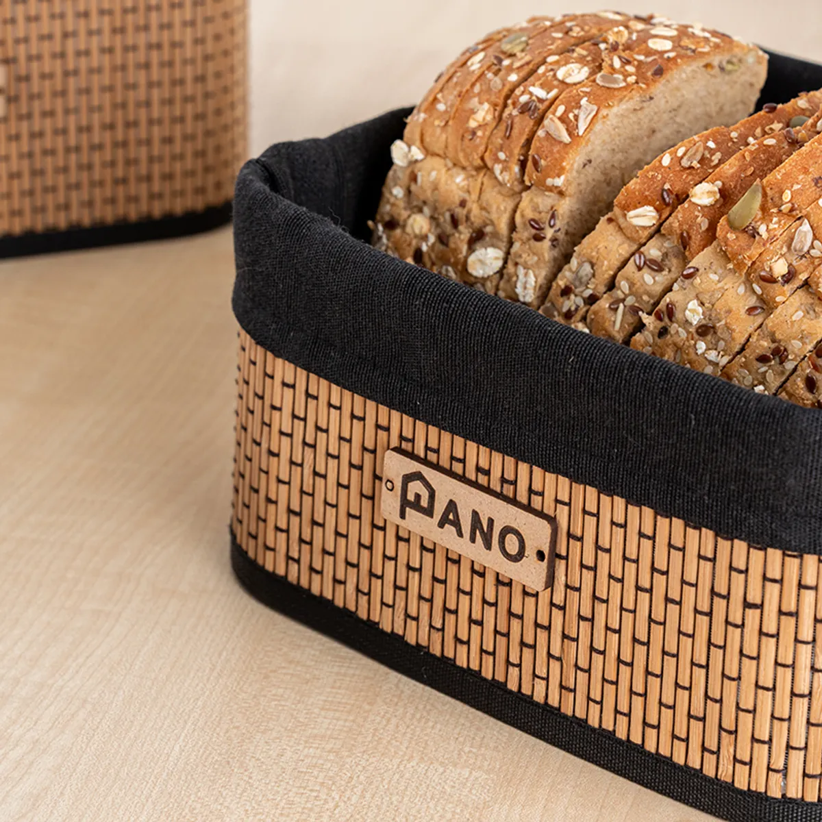 Close-up of a brown woven basket with black rim and bread inside