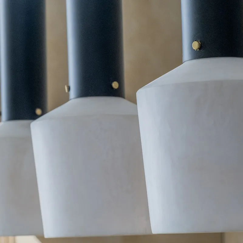 Close-up of off-white lamp shades with black cylindrical tops