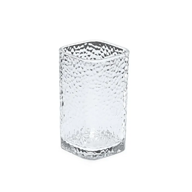 Single clear textured drinking glass with a softly squared rim