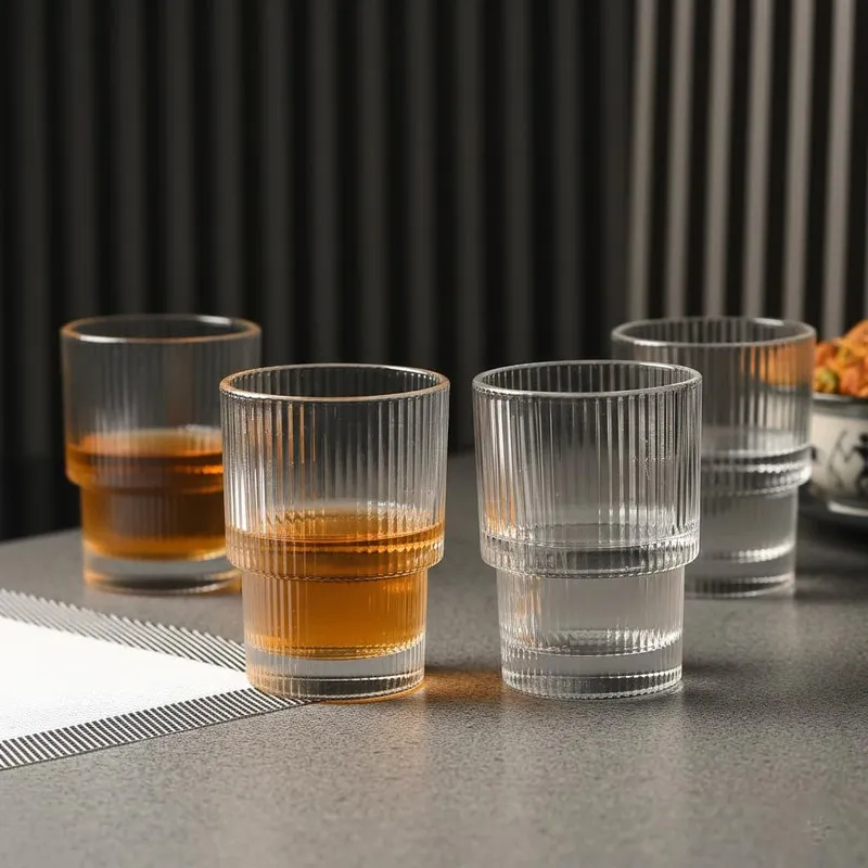 Close view of clear ribbed cocktail glasses with drinks on a table