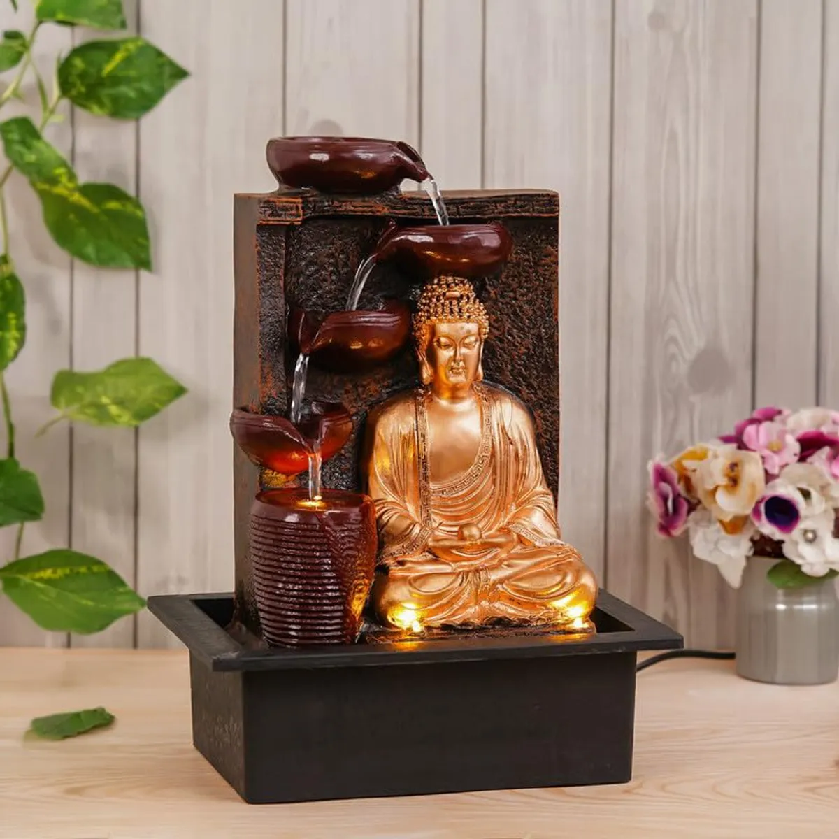 Angled view of maroon and gold Buddha LED fountain with flowing water