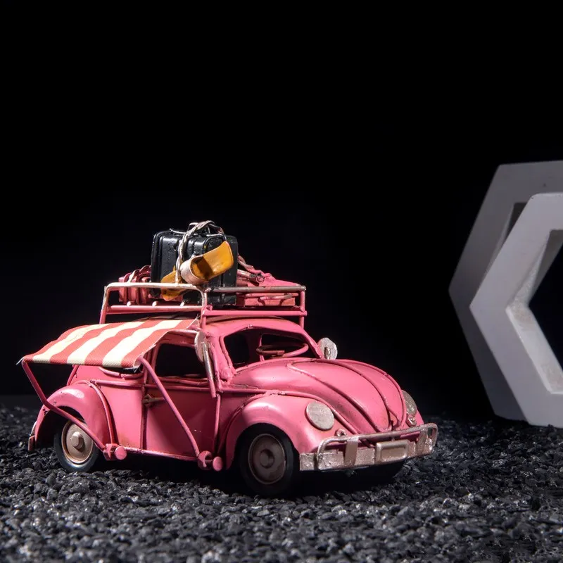 Pink vintage beetle car showpiece with striped side awning and rooftop luggage