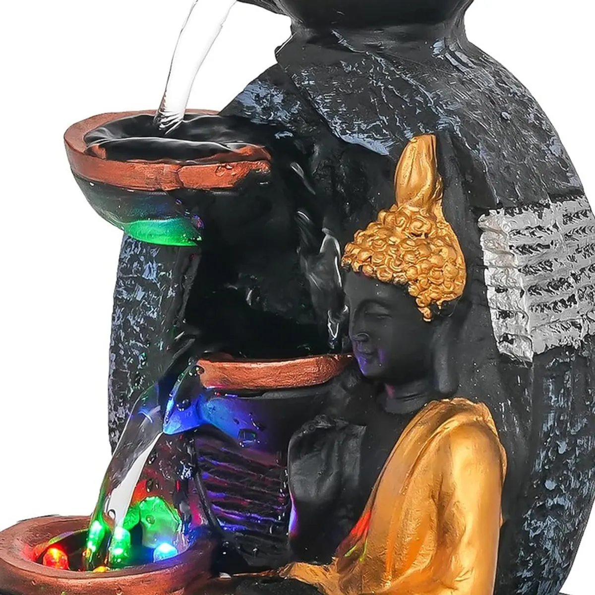 Close-up of Buddha figure, water cascade and illuminated bowls on the fountain