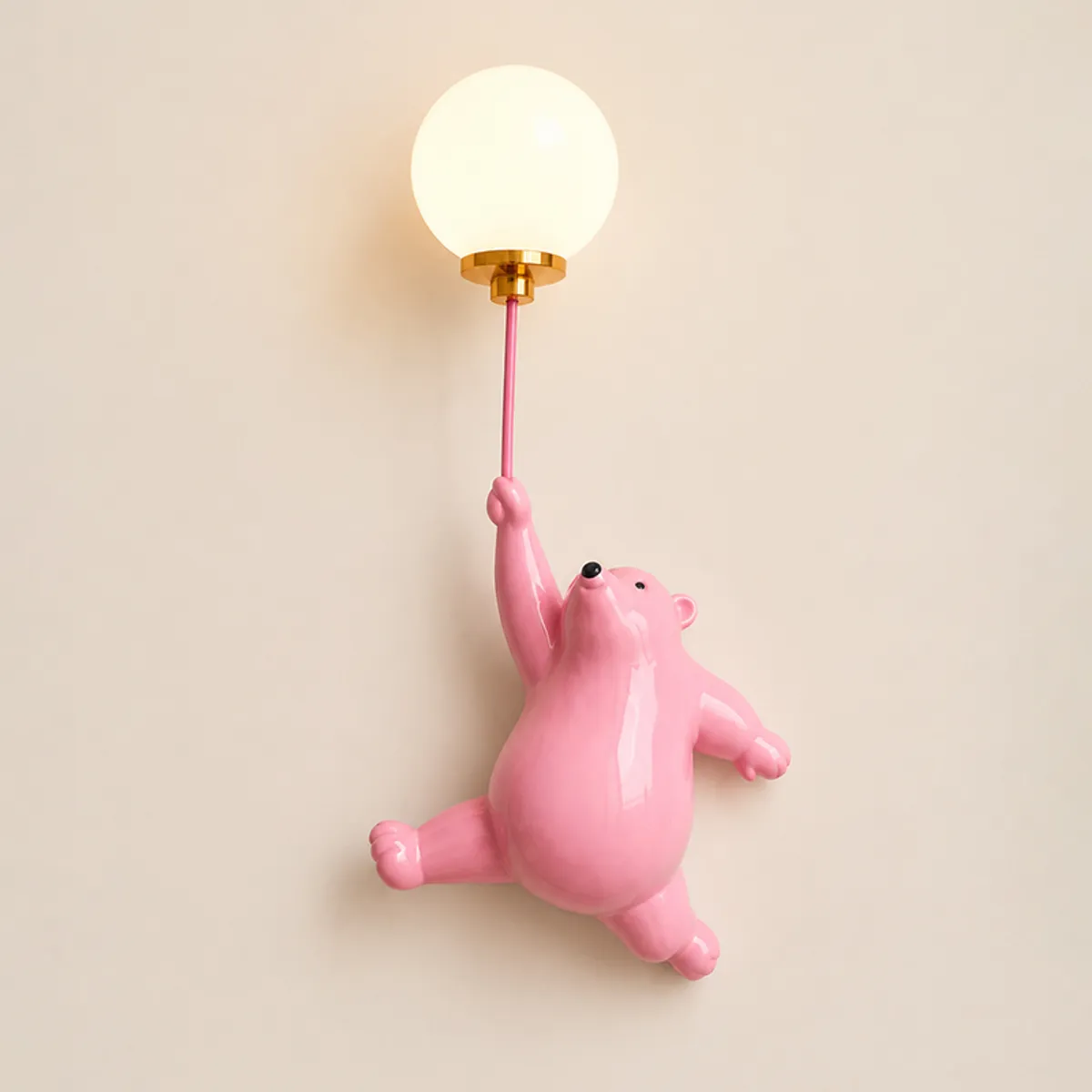 Close view of pink bear wall lamp with glowing globe