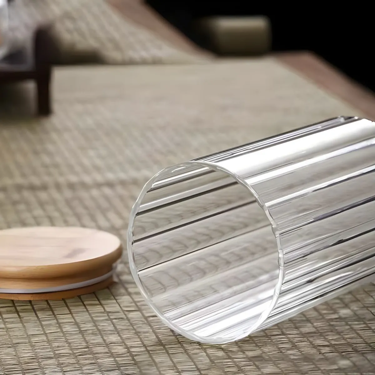 Clear fluted glass jar lying beside its bamboo lid on a tabletop.