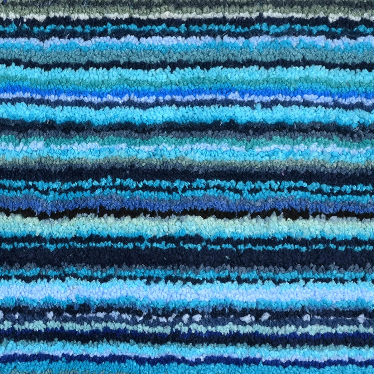 Close-up view showing the carpet's soft blue, teal and dark striped pile