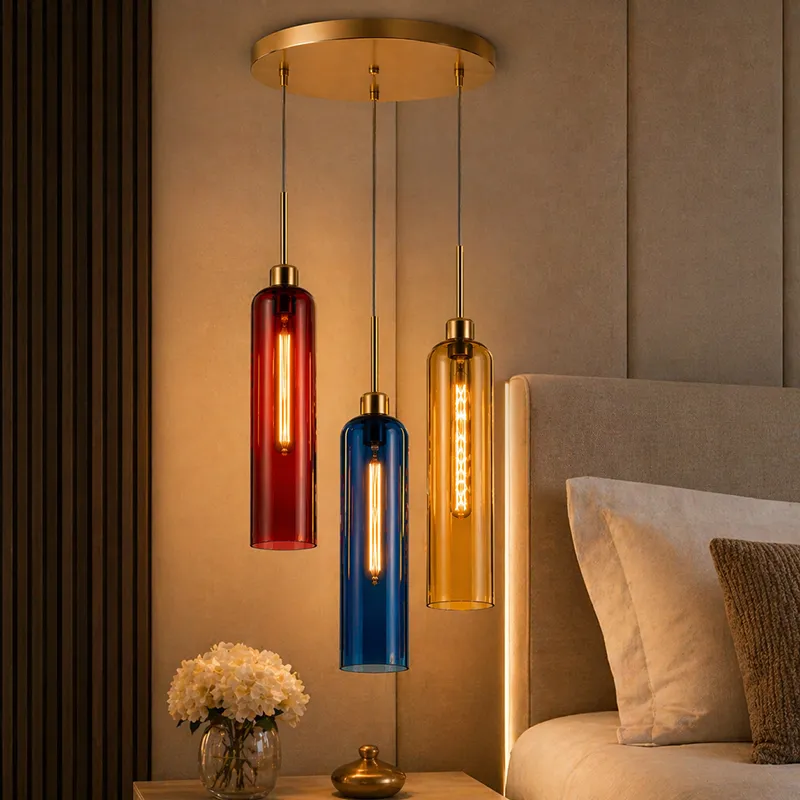 Clustered ceiling lamp with red, blue and amber glass shades beside a bed
