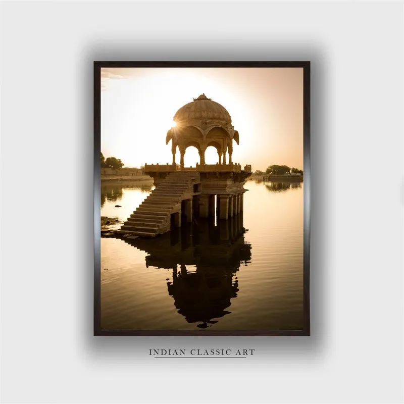 Framed wall painting showing a pavilion over a lake at sunset