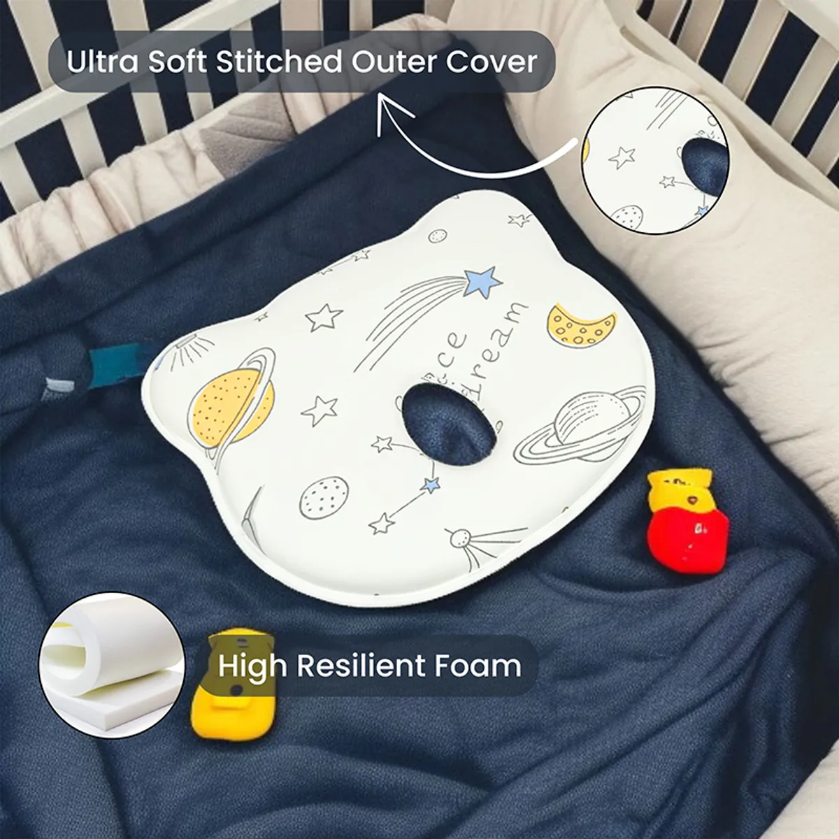 Baby pillow with central cutout and space-themed print on dark bedding