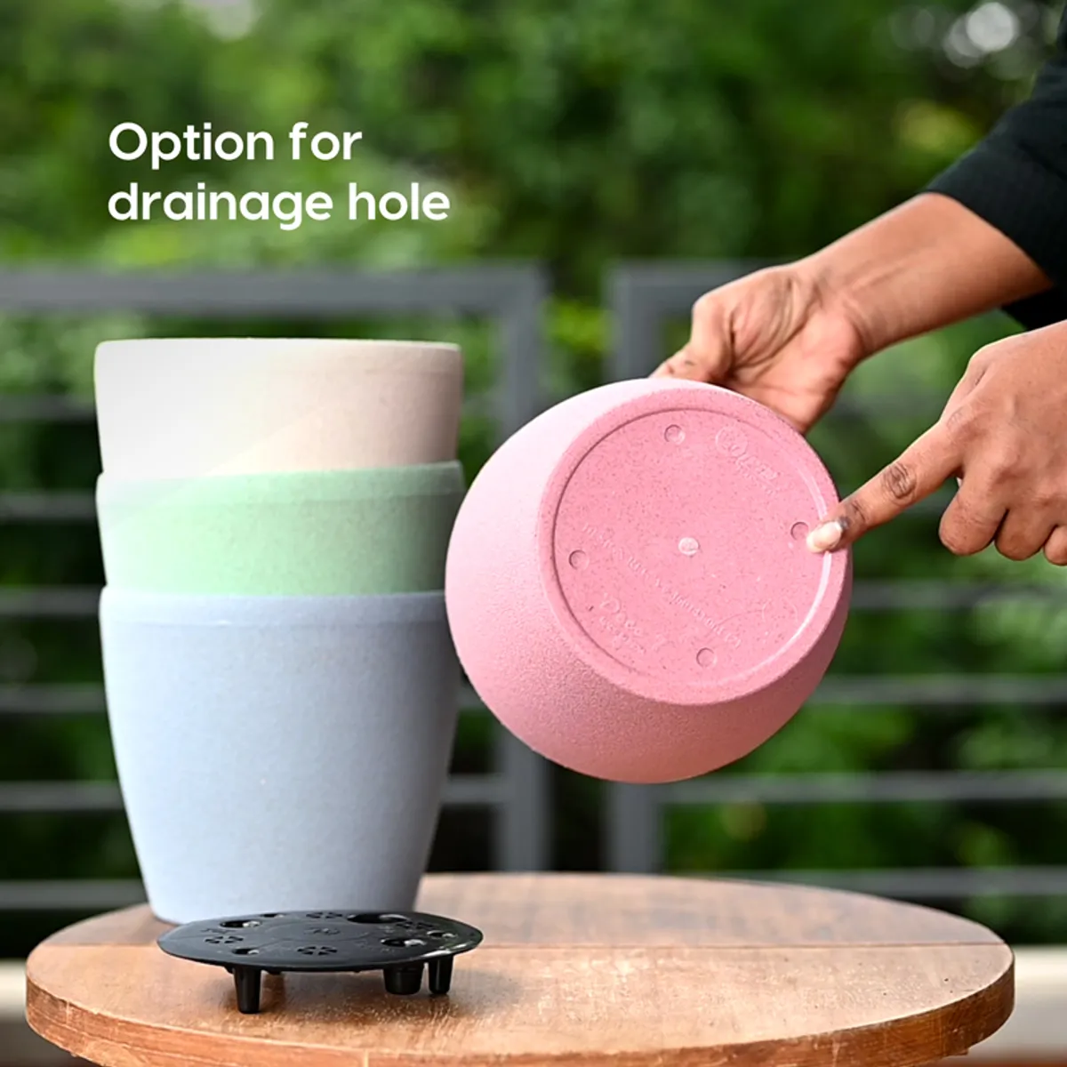 Upside-down pink planter showing the base beside a black tray