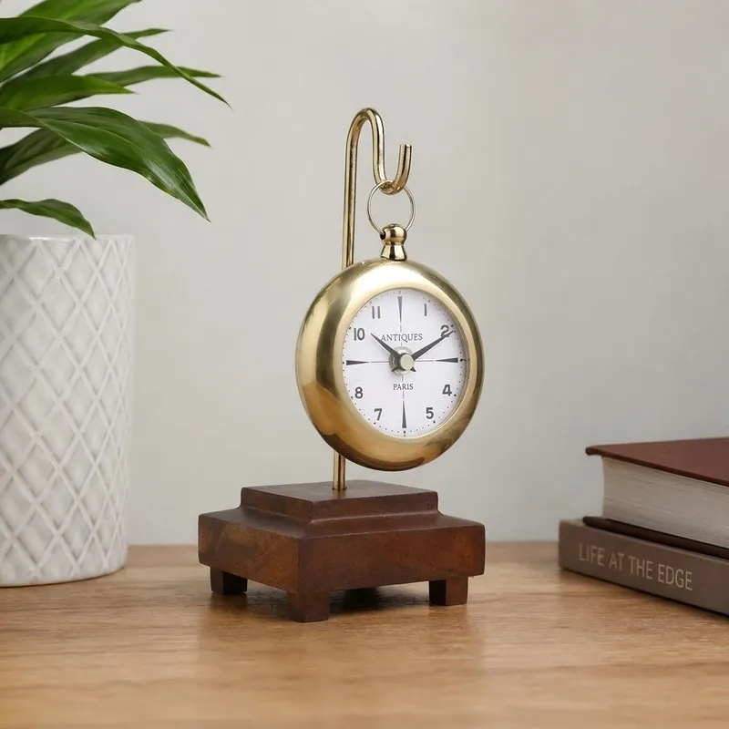 Gold round table clock with suspended design on a stepped wooden base