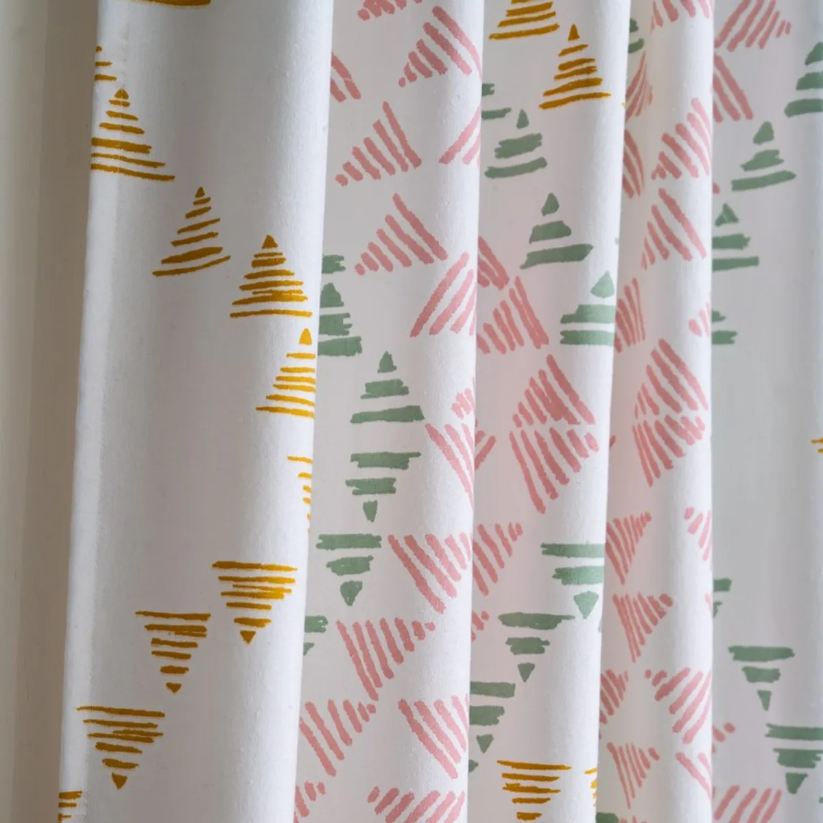 Close-up of pink, green and mustard geometric curtain pattern