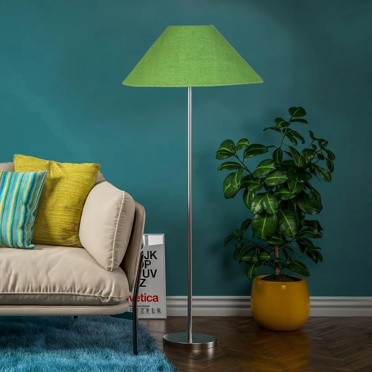 Green floor lamp with slim metal stand beside a sofa and potted plant
