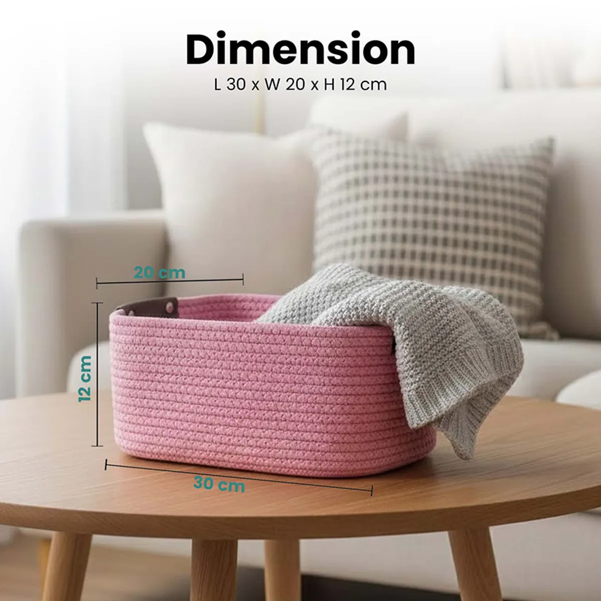 Pink rectangular basket on a table with a knitted throw draped over the edge