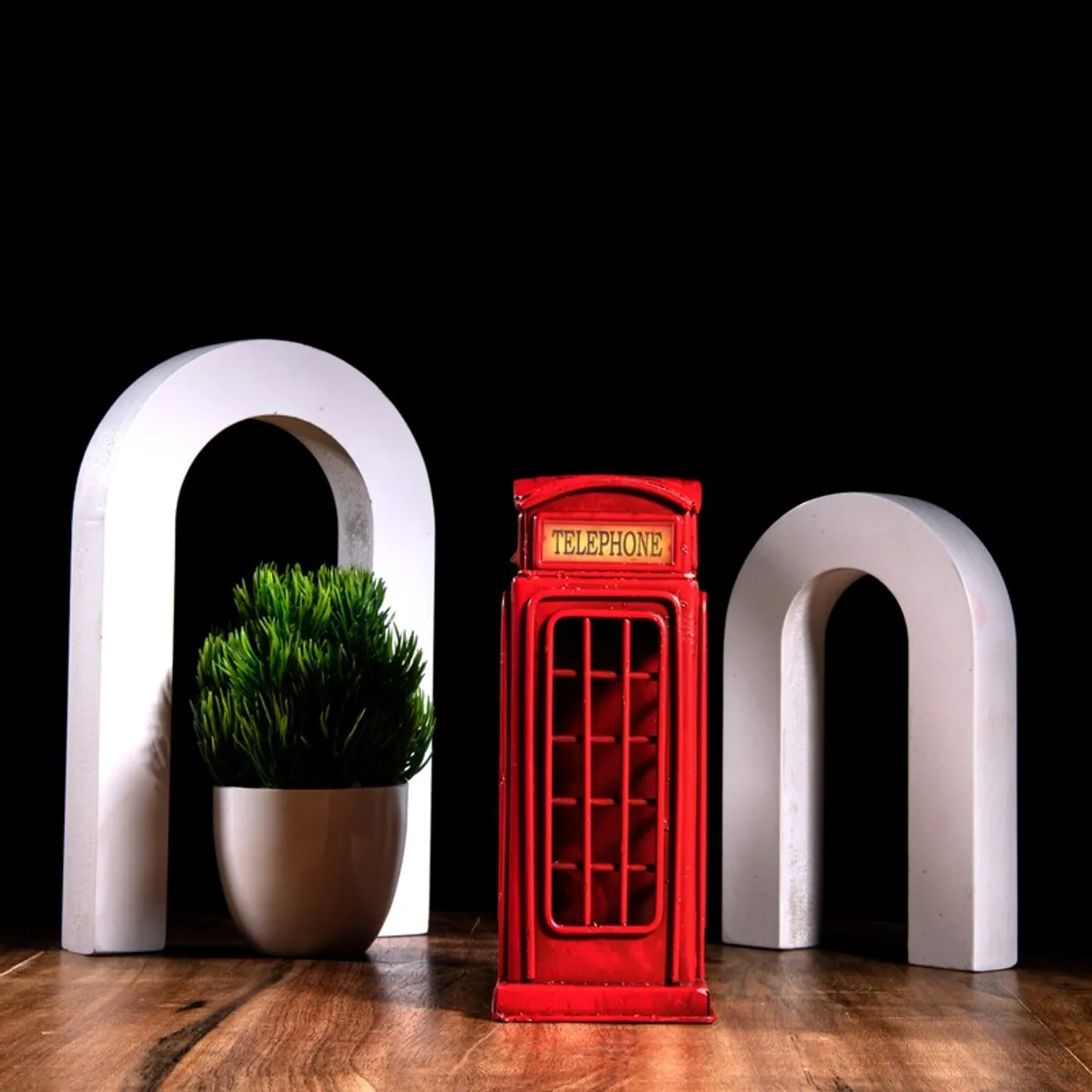 Front view of red telephone booth decor piece on wooden surface