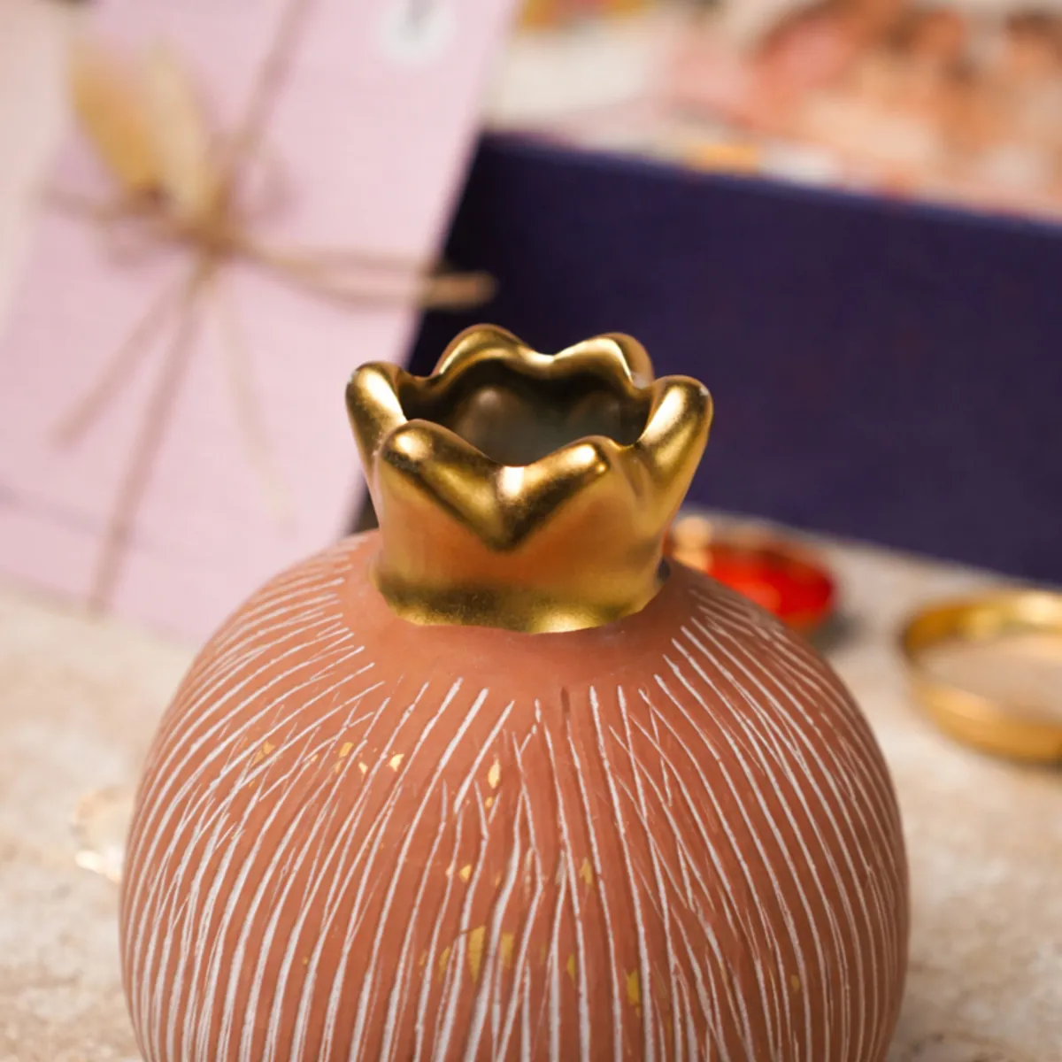 Close-up of the pomegranate vase showing its ridged surface and gold crown detail