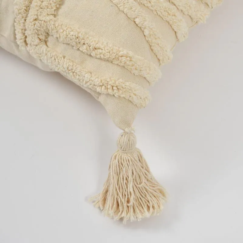 Close-up of a white cushion cover corner with tufted detail and tassel