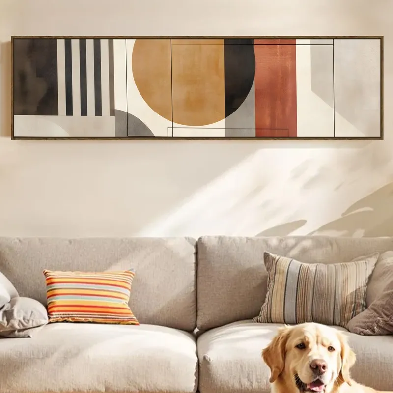 Wide framed abstract wall art above a sofa with a dog in the foreground