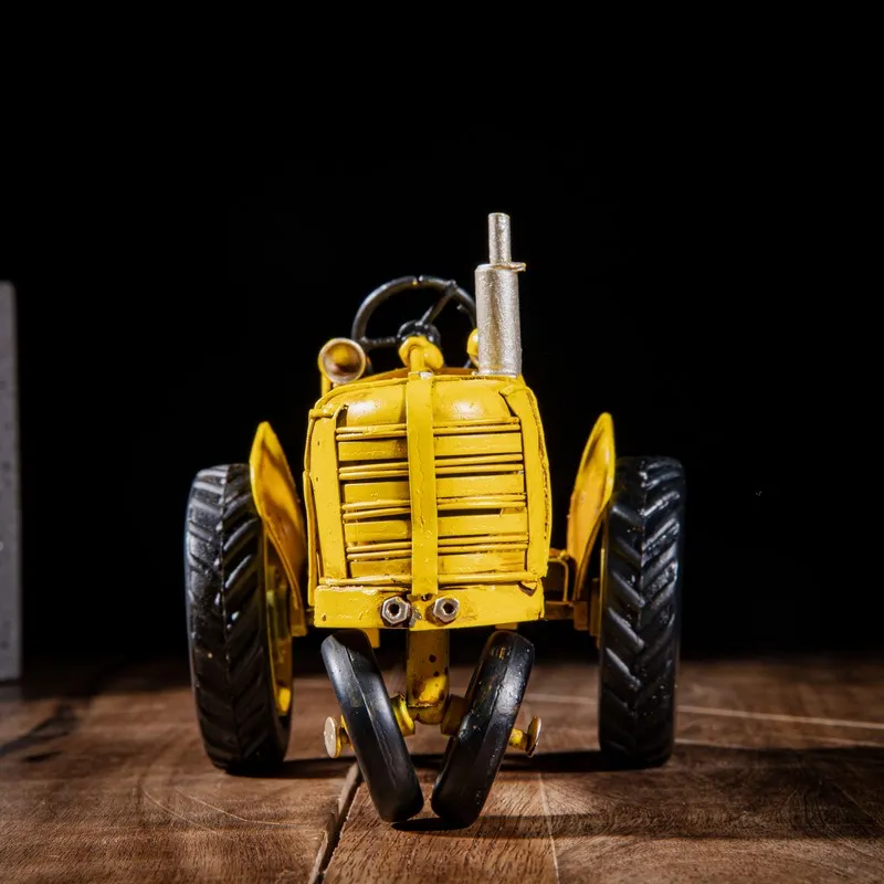 Front view of yellow tractor showpiece with black wheels