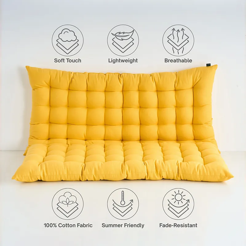 Mustard yellow tufted floor cushion against a plain wall