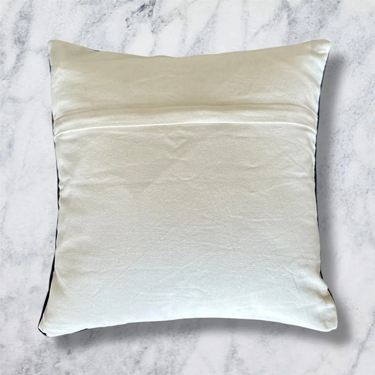 Back of the cushion cover in plain off-white fabric