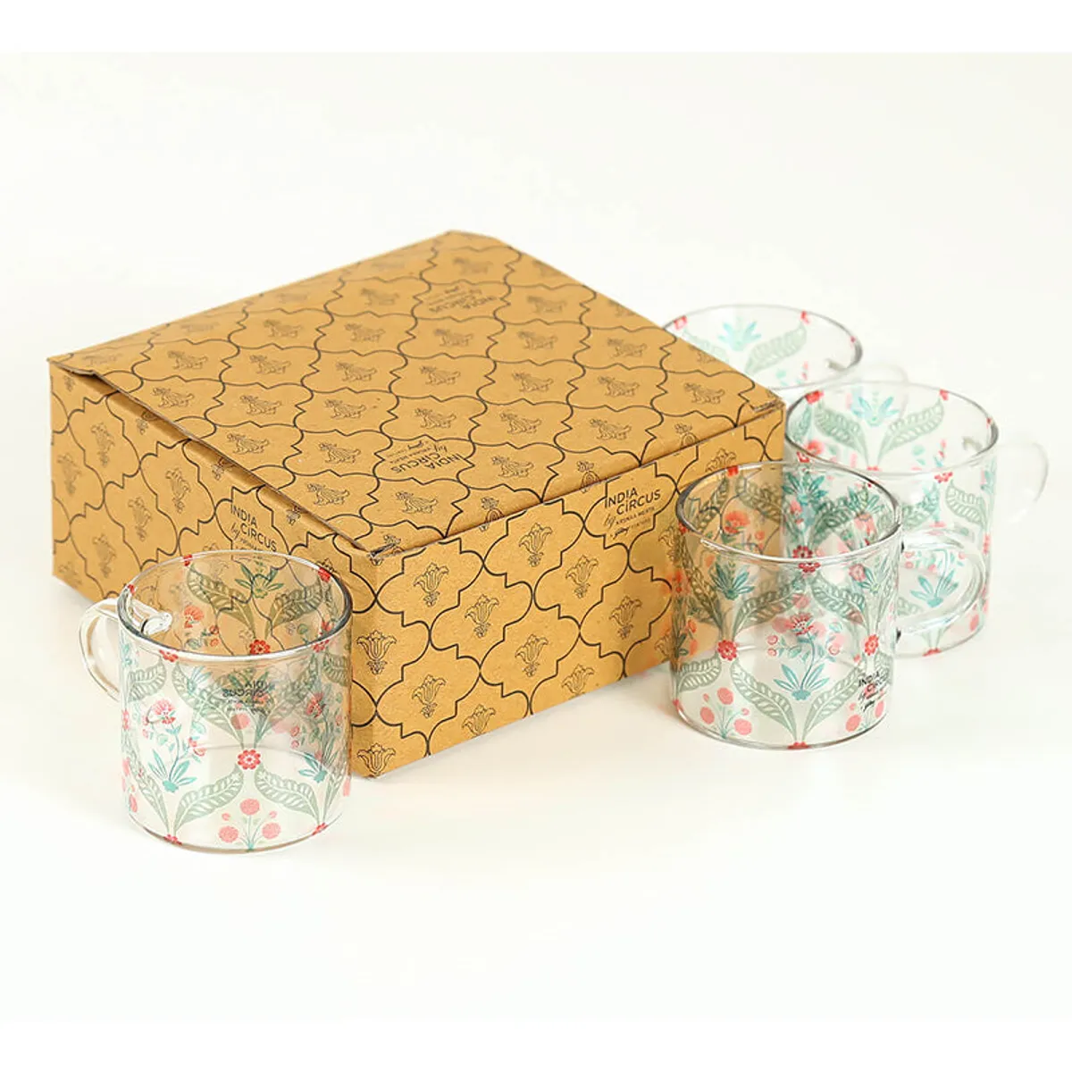 Set of floral glass mugs placed beside a patterned gift box