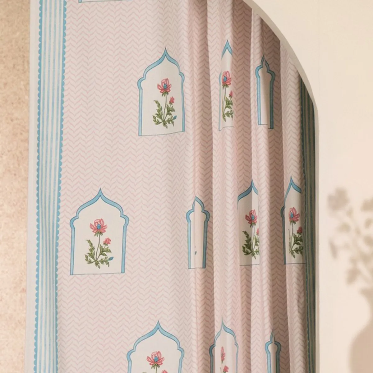 Close-up of floral arch motifs and blue edging on curtain fabric