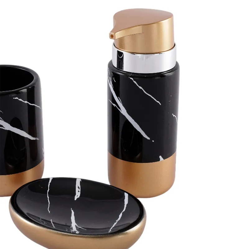 Close view of glossy black and gold soap dispenser and marbled soap dish
