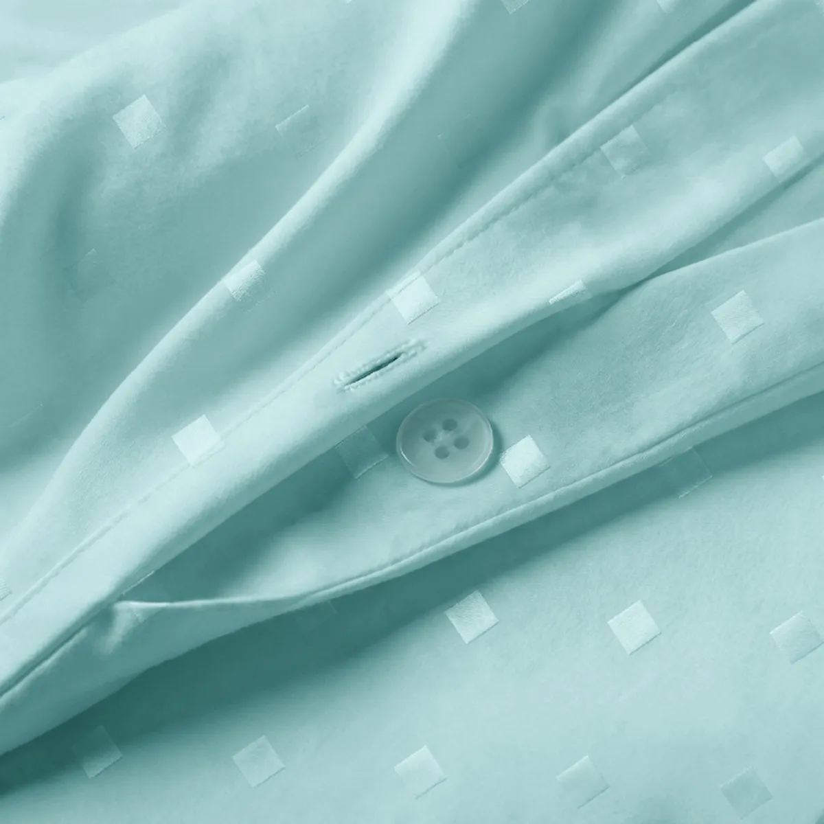 Close-up of pale turquoise dotted cotton duvet cover with button closure