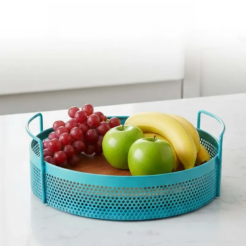 Blue round metal basket with handles holding fruit