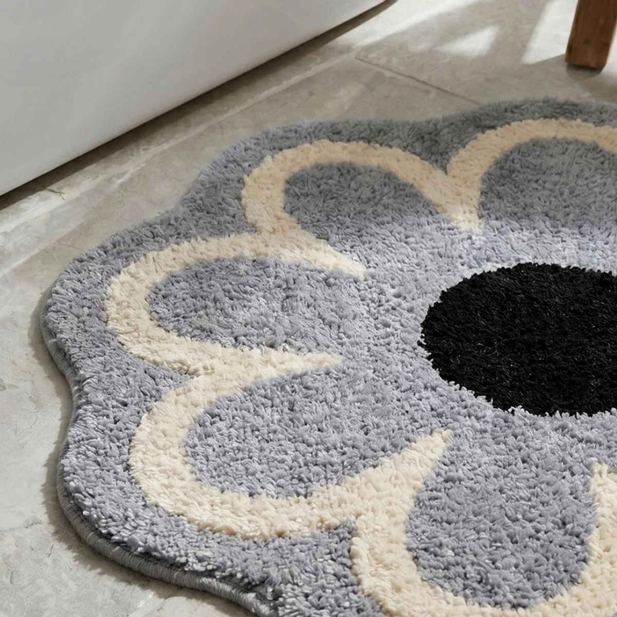 Close-up of the soft, textured grey and cream floral surface of the bath mat.