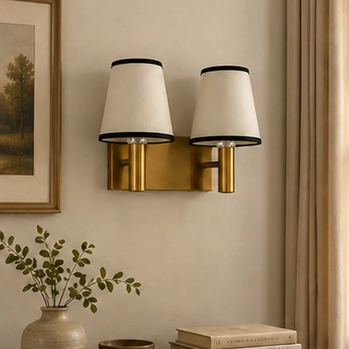 Front view of a twin white-shade wall lamp with black trim and gold-toned base