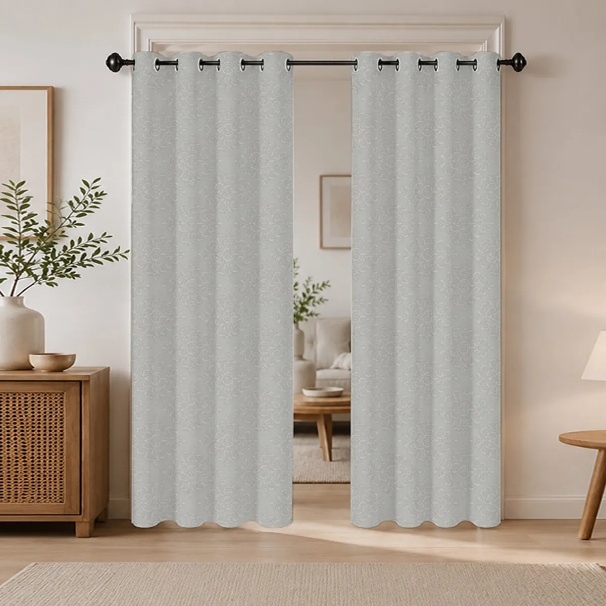 Grey patterned eyelet curtains hanging in a warm living room setting