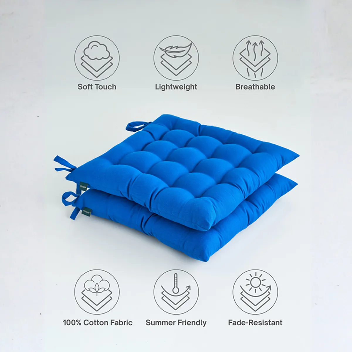 Two blue tufted chair pads stacked with soft-touch and cotton fabric icons.