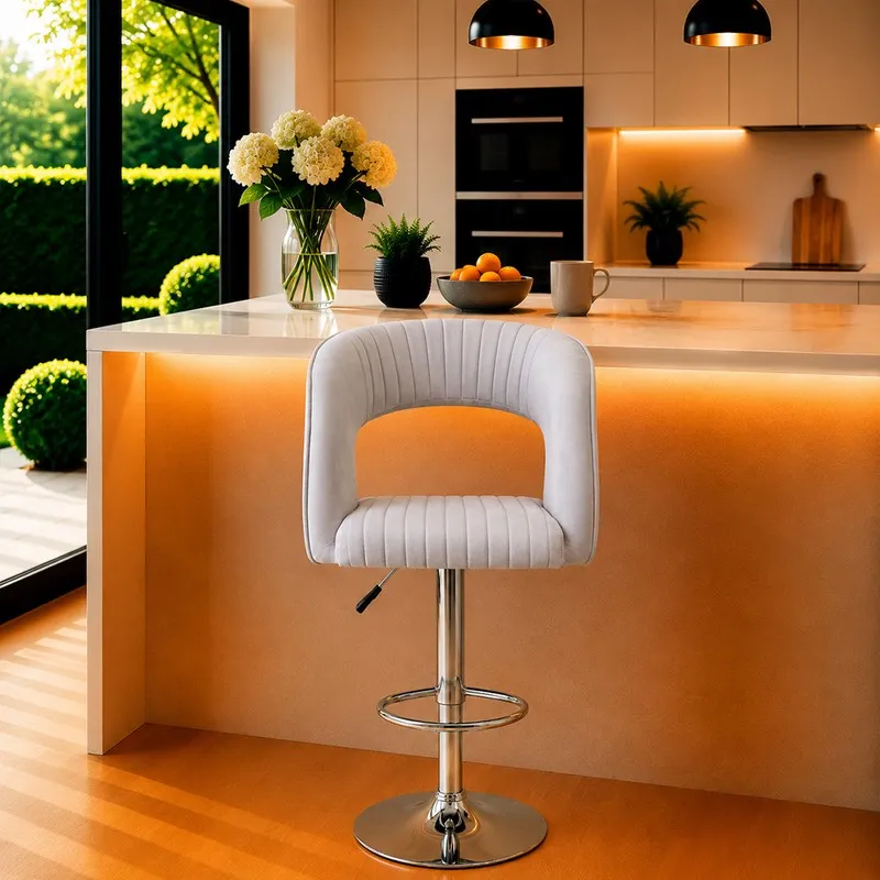 Grey velvet bar chair with curved back, ribbed seat and chrome pedestal base