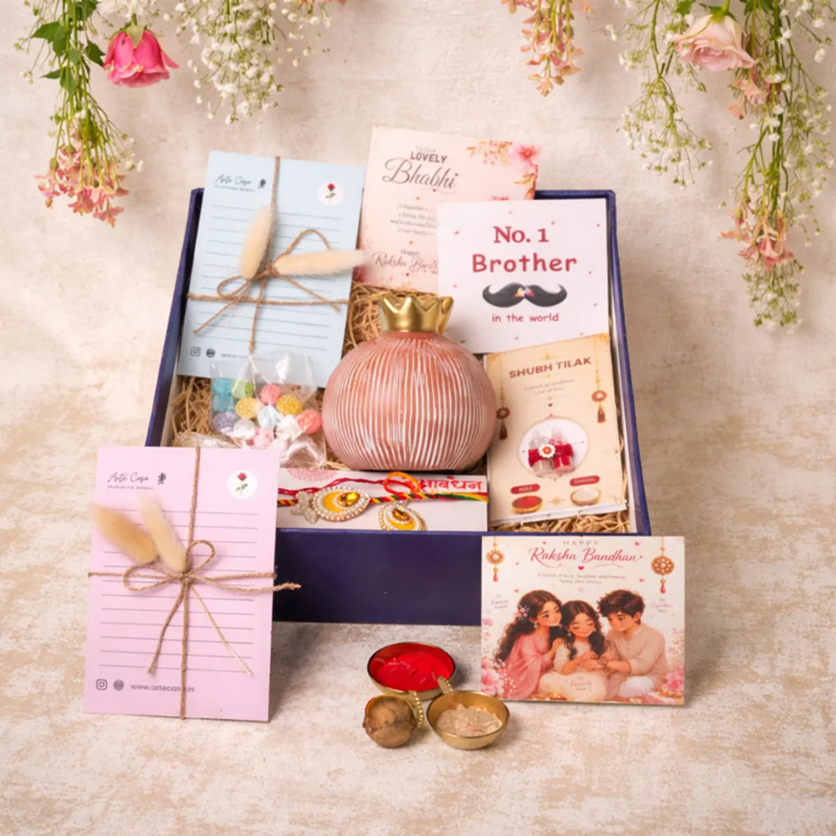 Open Rakhi hamper arranged with vase, rakhis, cards, candies and ritual items