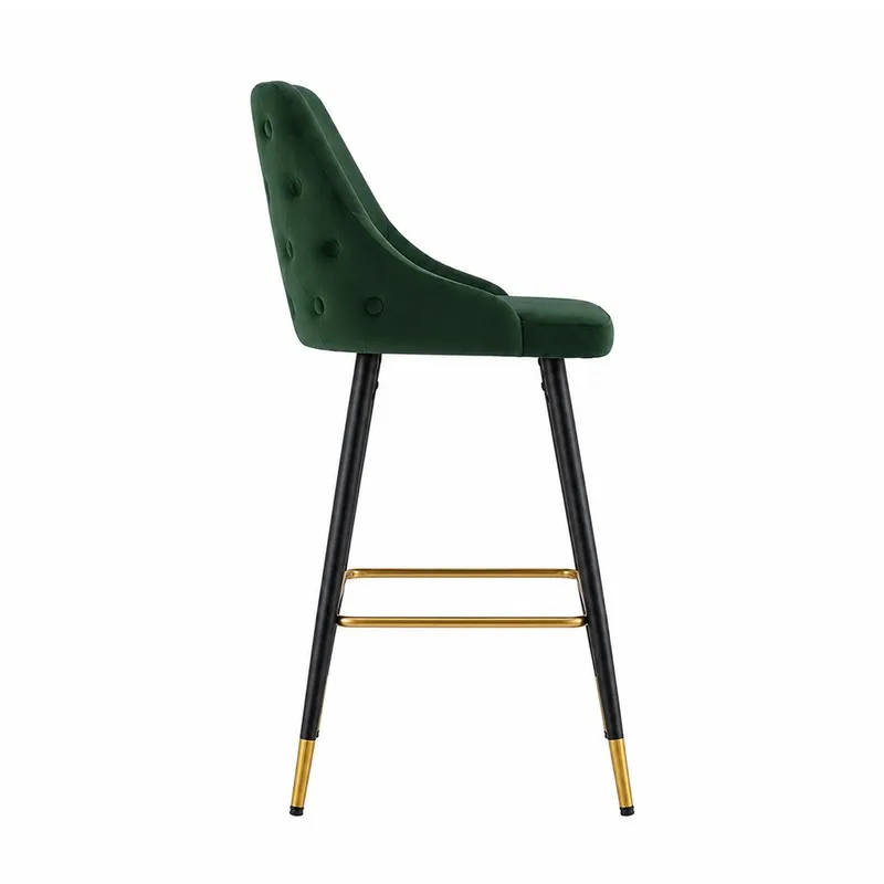 Side view of a green velvet bar chair with button-tufted back